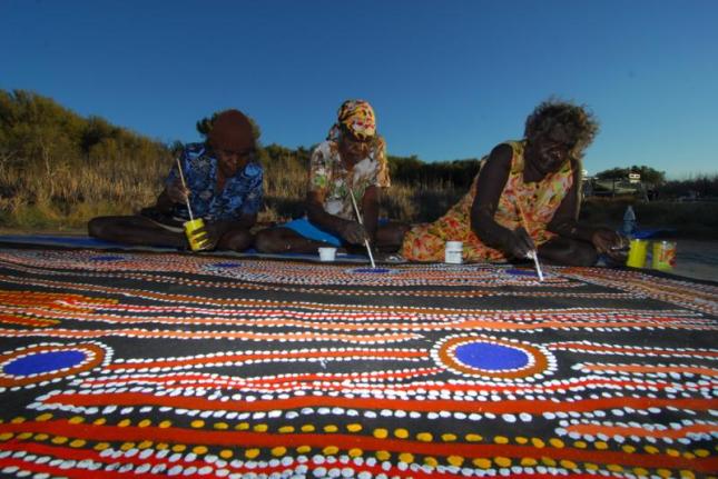 Photo of 3 women working on a collaborative painting