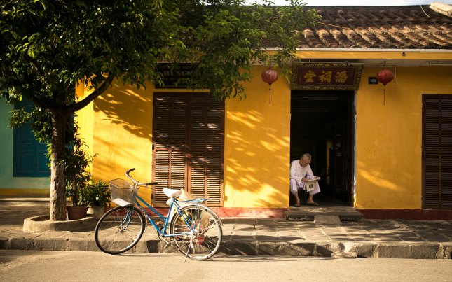 Man reading a newspaper in a doorway