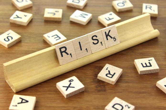Scrabble tiles reading "RISK"