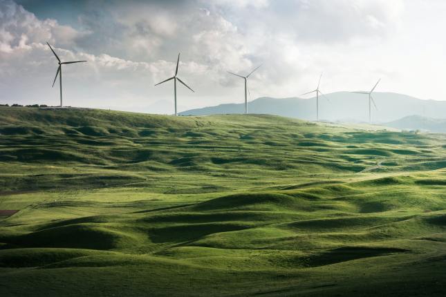 Photo of wind turbines on a green hillside