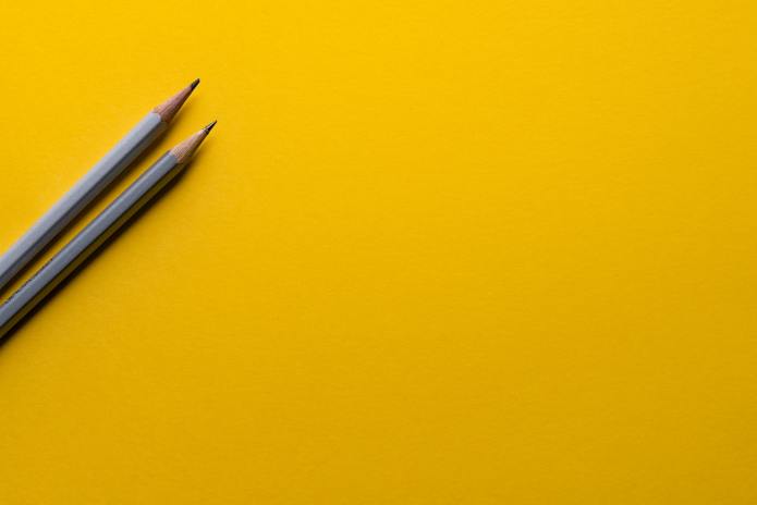 Photo of two pencils on a yellow background